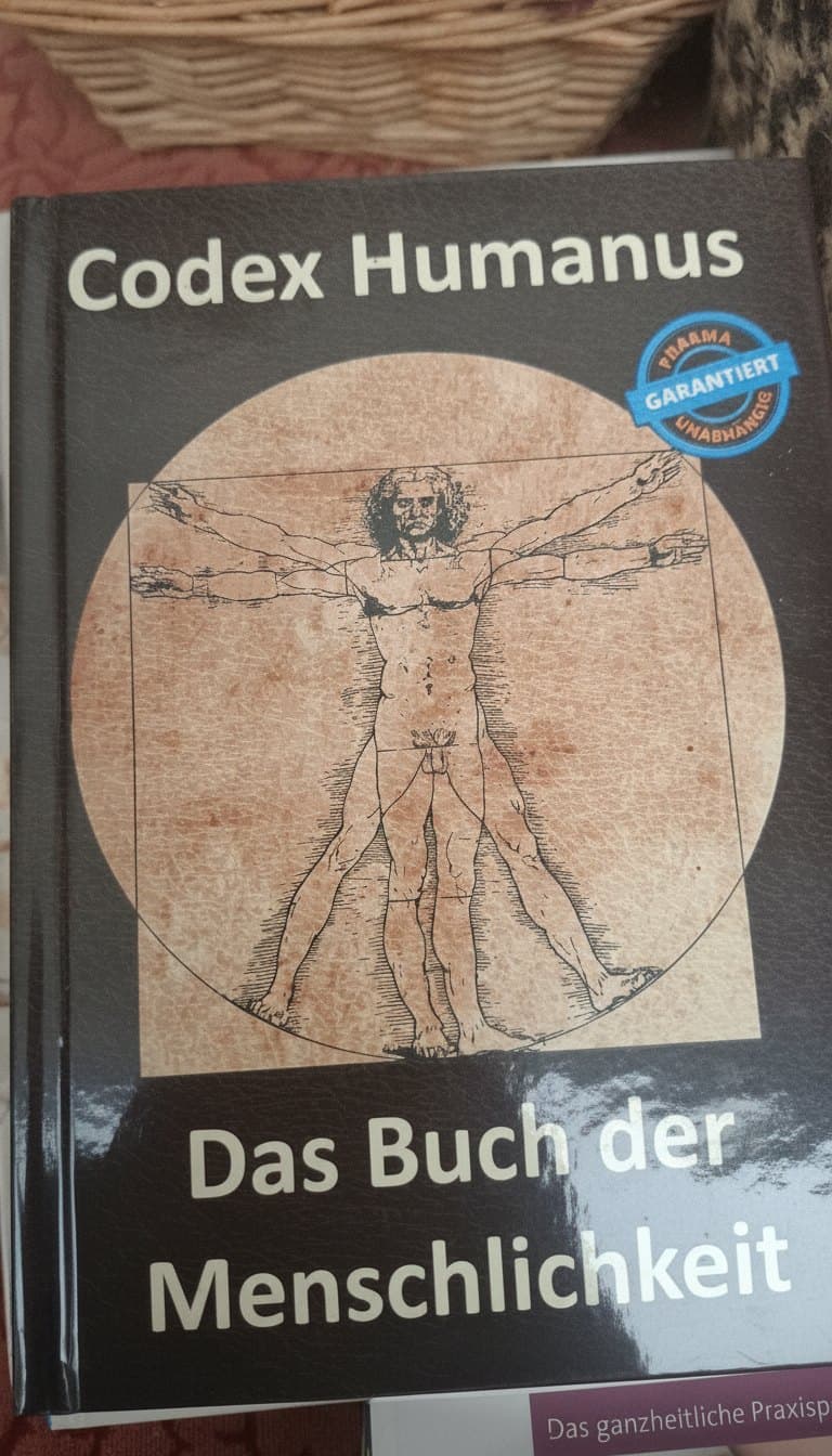 Gebundenes Buch mit der Zeichnung des vitruvianischen Menschen auf dem Einband, in Ritas Regal